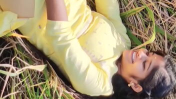 A pretty woman in a yellow outfit has sex outdoors in a field with a well-endowed man.